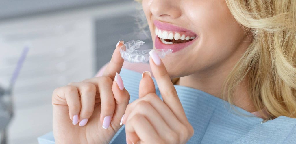 Female patient holding invisible braces